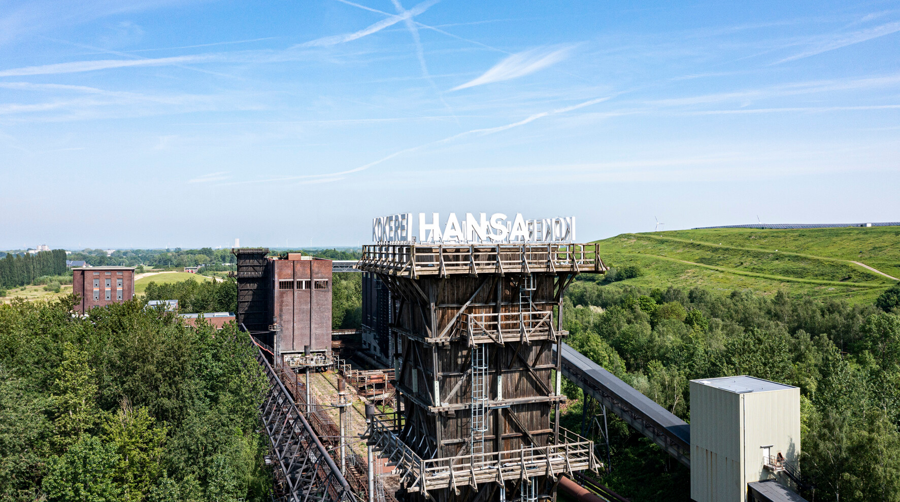 Kokerei Hansa in Dortmund © Klaus-Peter Schneider Turm der Kokerei Hansa in Dortmund, umgeben von Bäumen und dem grünen Deusenberg, einem rekultivierten Deponiegelände