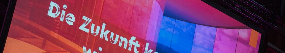 Beim Tourismustag NRW x Ruhrgebiet 2026 in der Kokerei Hansa in Dortmund steht auf einer Präsentationsfolie "Die Zukunft kommt nicht - wir gestalten sie!"