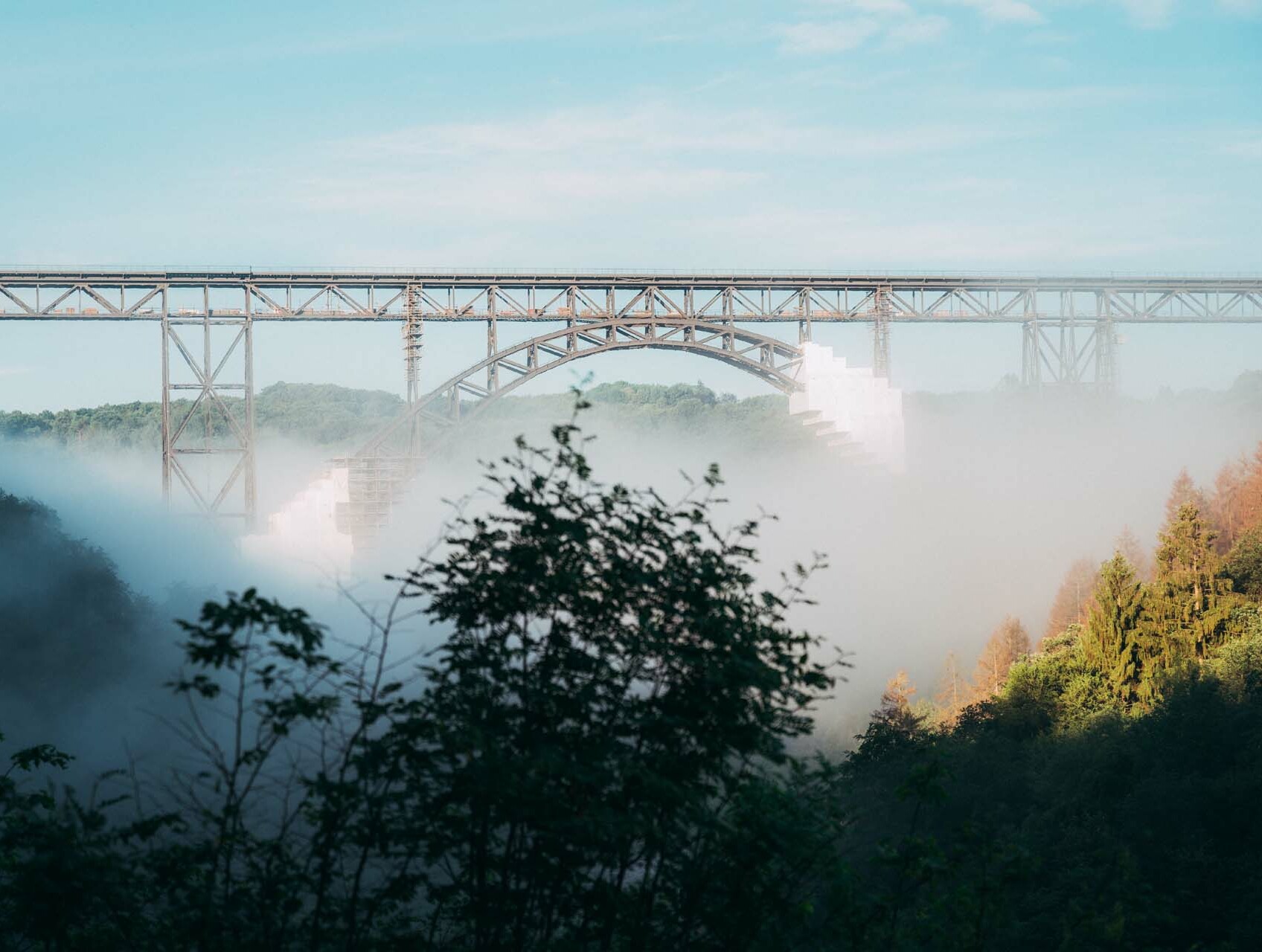 Nebel wabert durch die Bäume und Sträucher am Fuße der 107 Meter hohen Müngstener Brücke zwischen Solingen und Remscheid. 