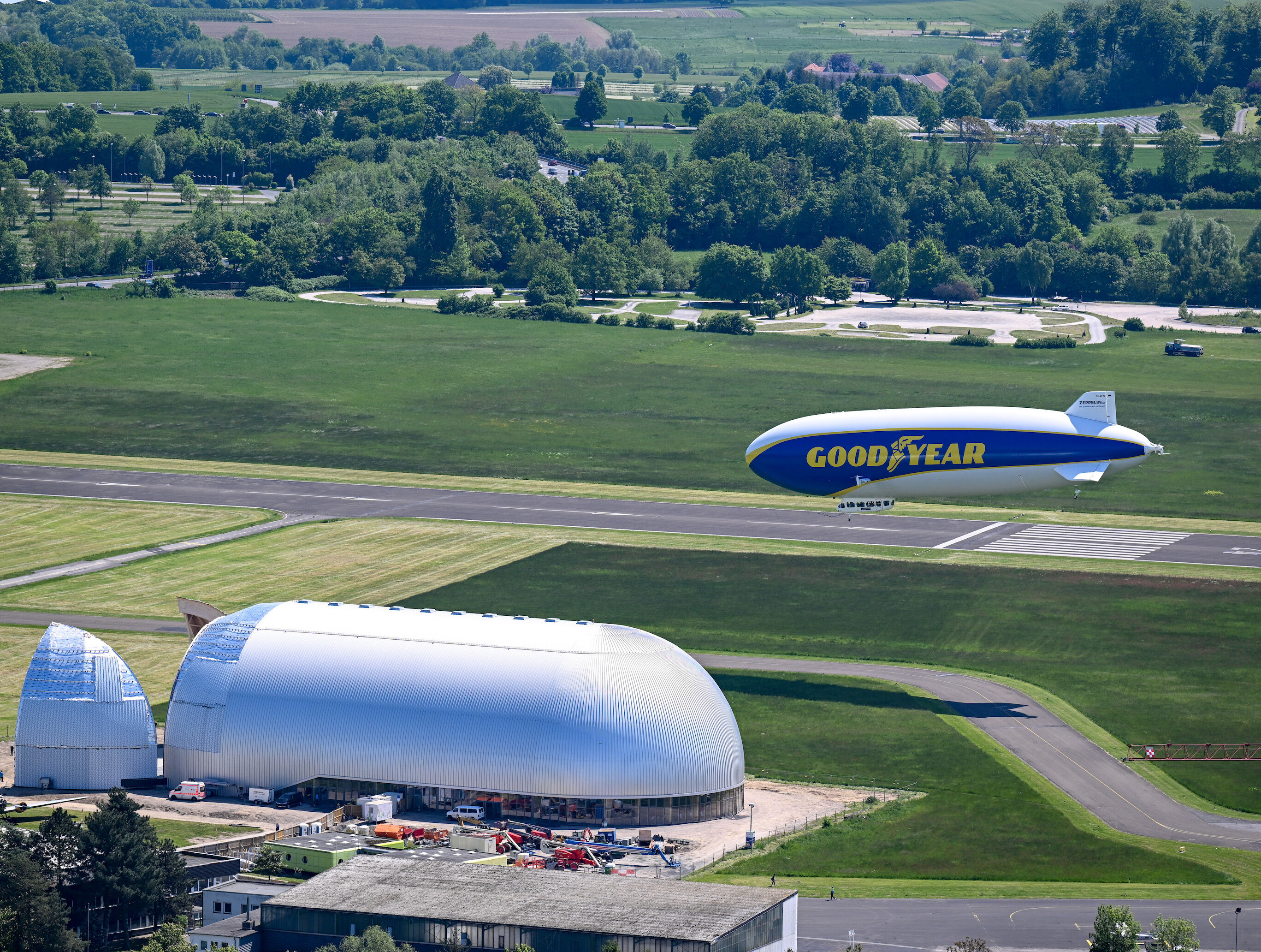 Ein Zeppelin schwebt über einem Flughafen.