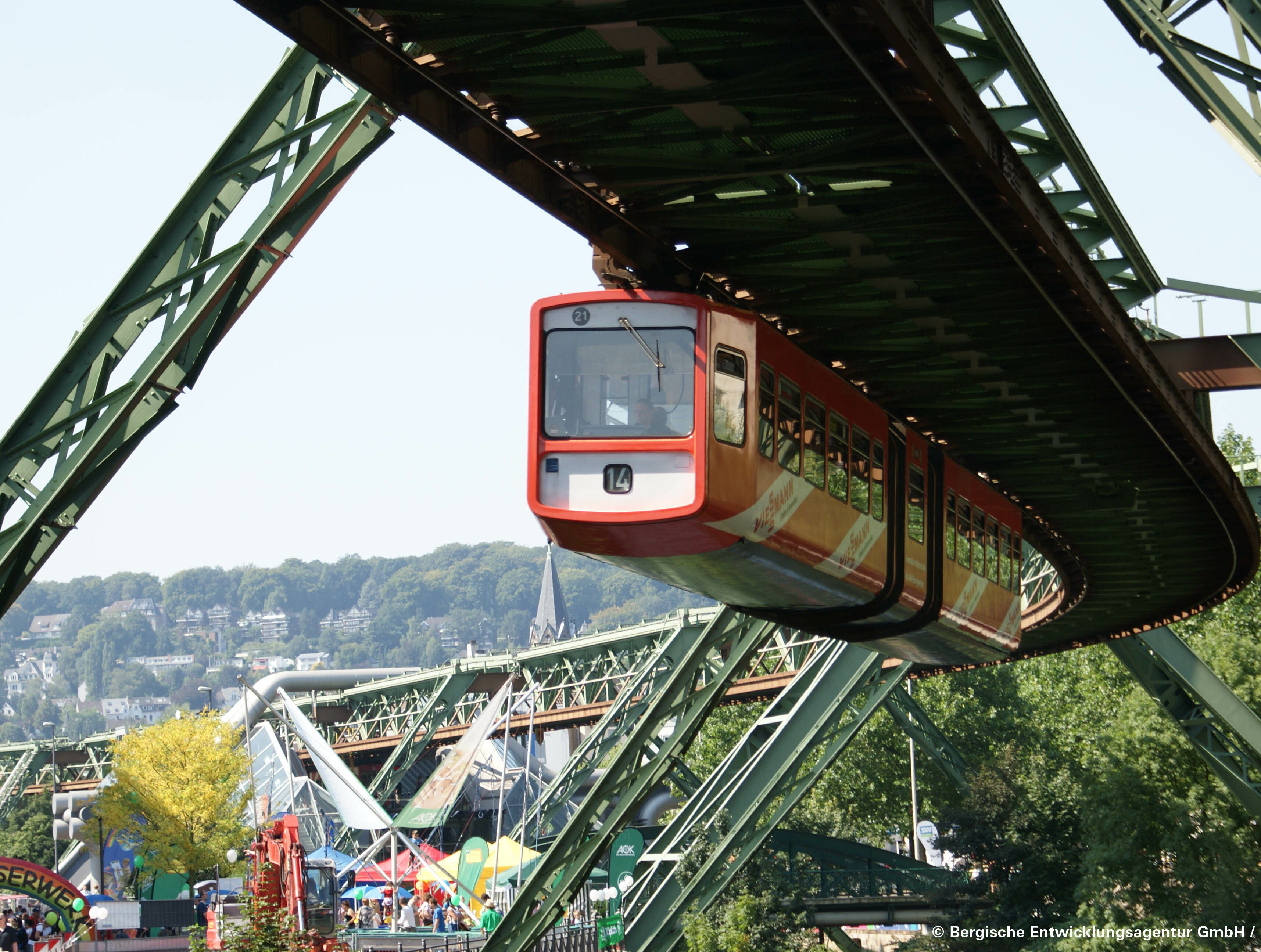 Die Wuppertaler Schwebebahn schwebt unter den Gleisen über die Stadt.