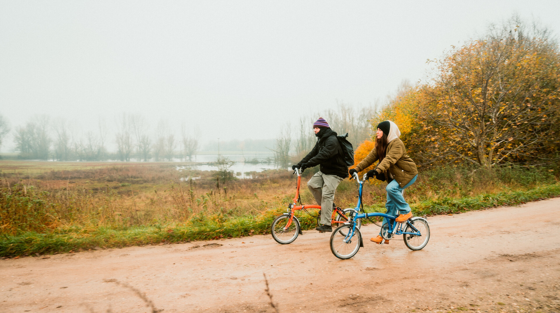 Zwei Menschen fahren auf Fahrrädern durch ein Naturschutzgebiet am Niederrhein. 