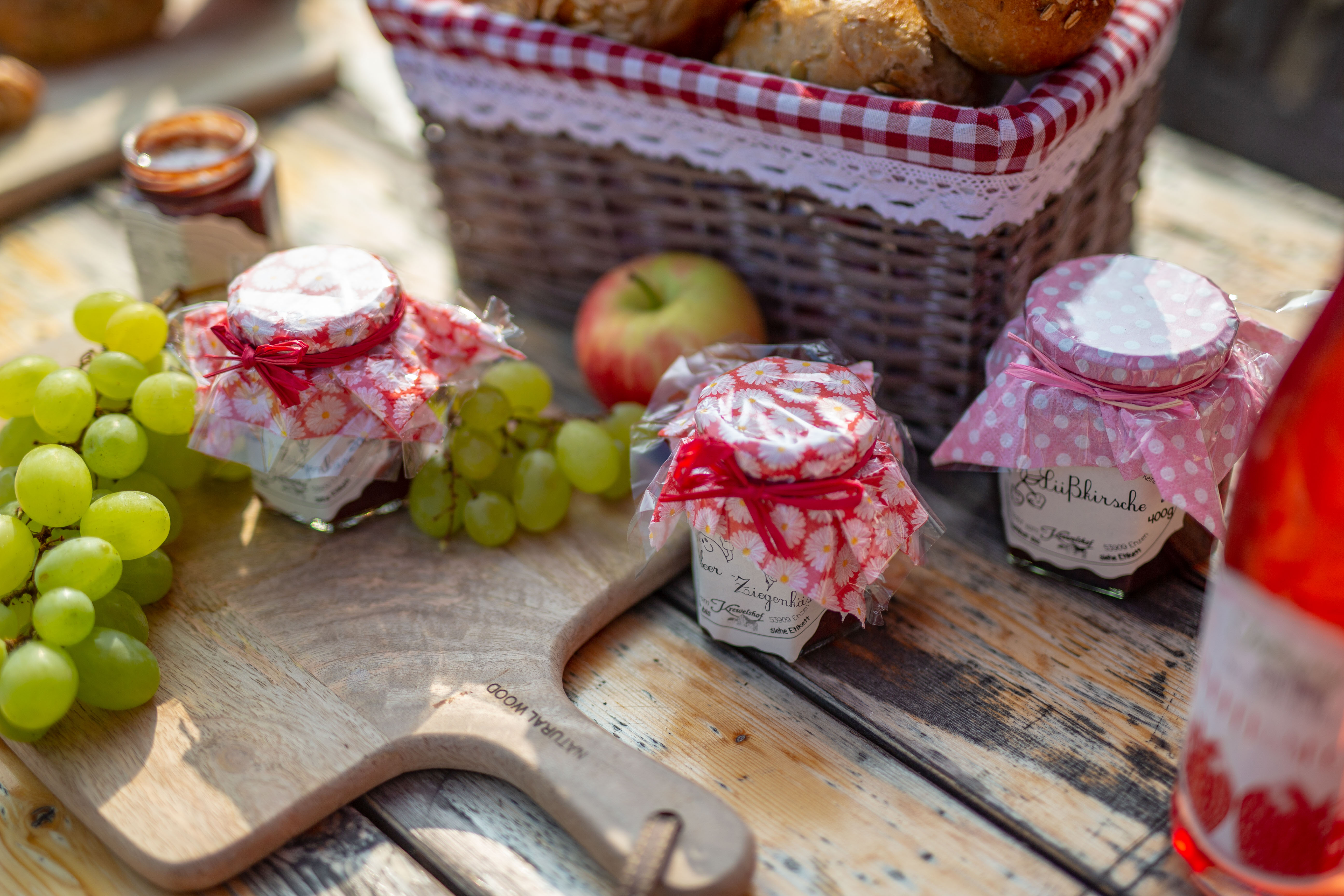 Mit Brötchenkorb, Marmelade und Weintrauben gedeckter Tisch im Krewelshof in Lohmar 