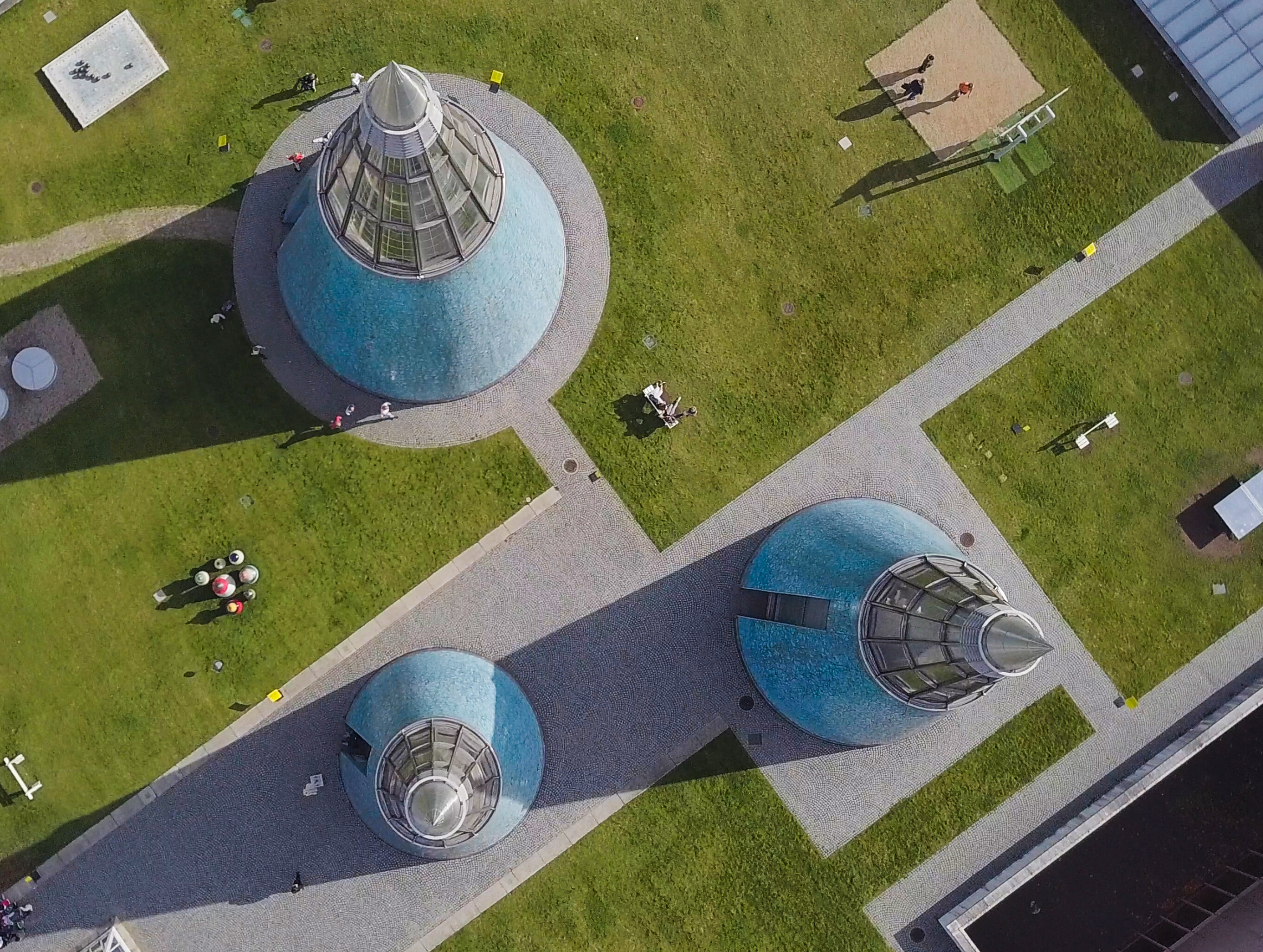Dach der Bundeskunsthalle in Bonn © Tourismus NRW e.V. Blick von oben das begrünte und begehbare Dach der Bundeskunsthalle in Bonn mit drei bläulichen, zugespitzten Lichtkegeln.