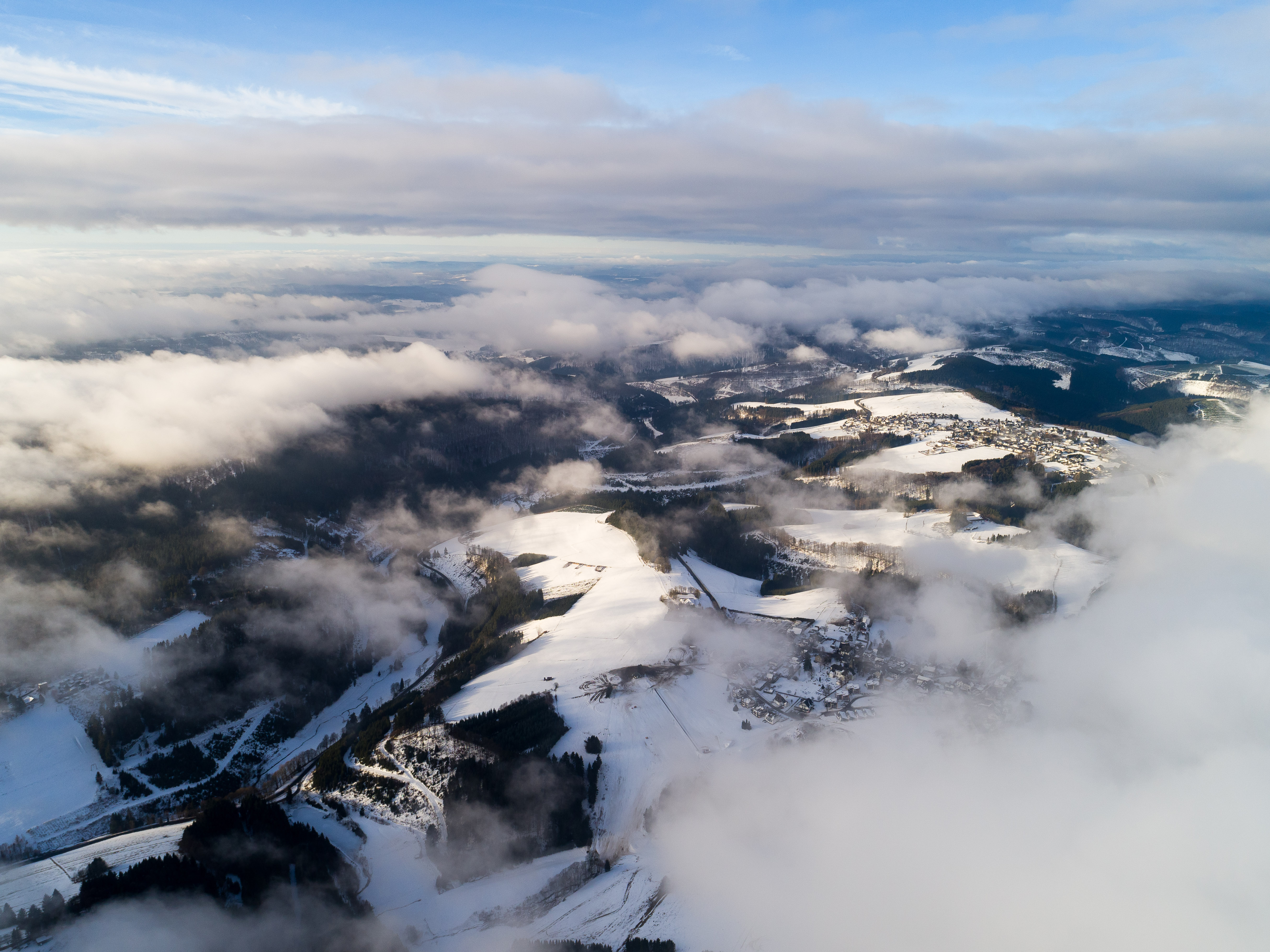 Wolken ziehen über die schneebedeckten Berge am Kahlen Asten bei Winterberg im Sauerland. © Tourismus NRW e.V.