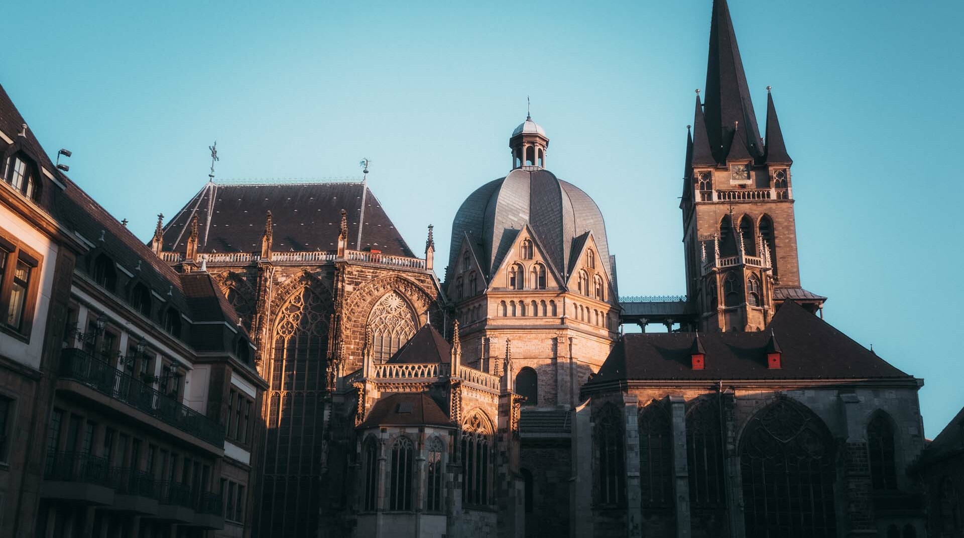 Aachener Dom bei Sonnenuntergang vor strahlend blauem Himmel