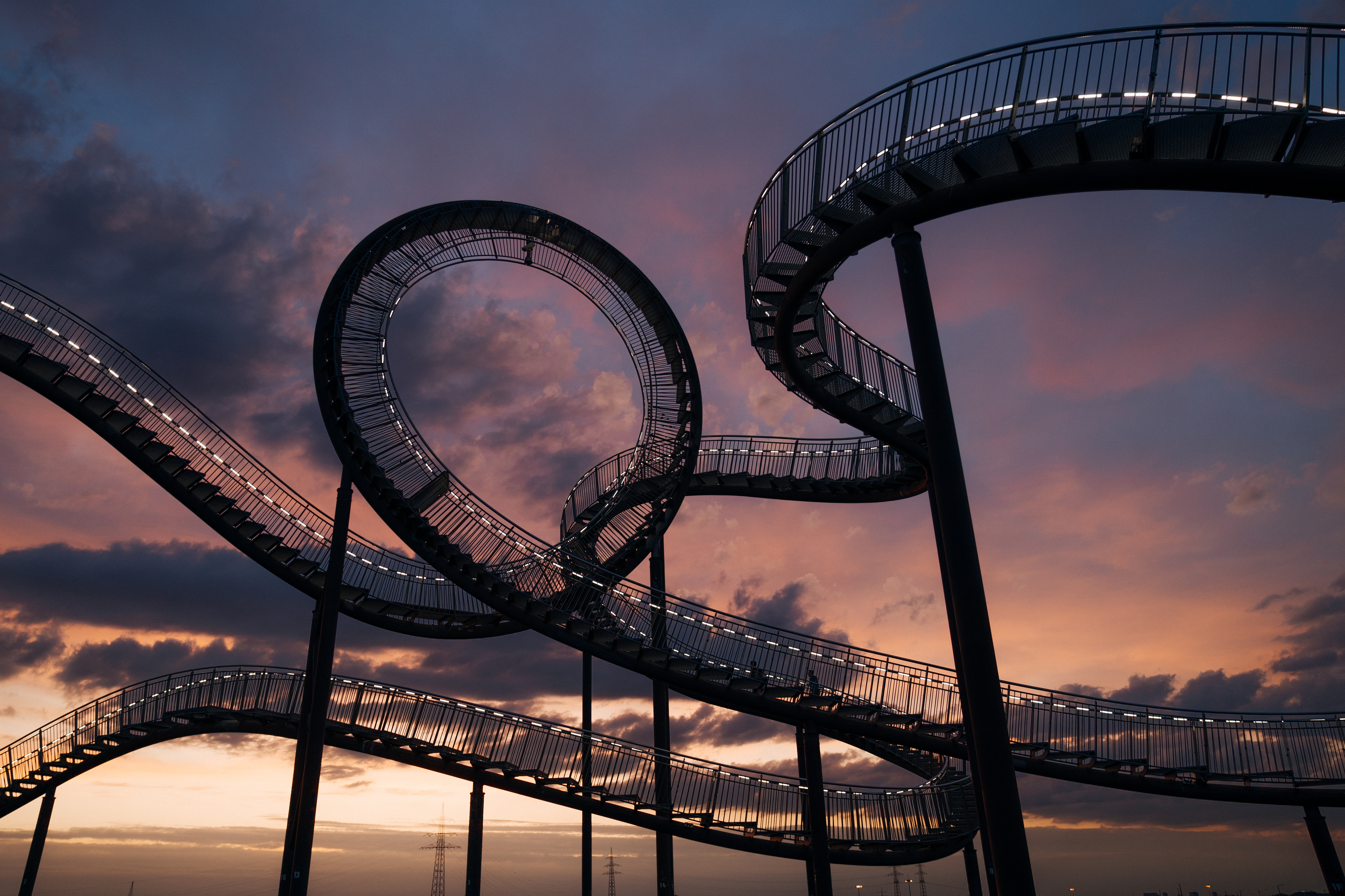 Stimmungsvolle Aufnahme der beleuchteten Skulptur "Tiger and Turtle" des Künstlerduos Heike Mutter und Ulrich Genth in Duisburg bei Sonnenaufgang