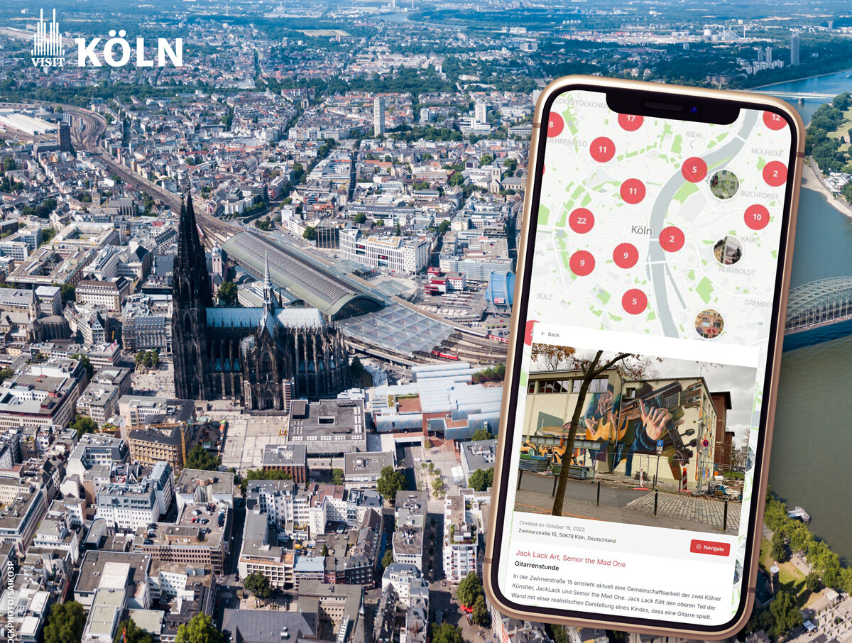 Auf einem Handy ist die Urban Art Map für Köln zu sehen, mit deren Hilfe man Street-Art in Köln entdecken kann. Das Handy liegt auf einer Ansicht von Köln.  