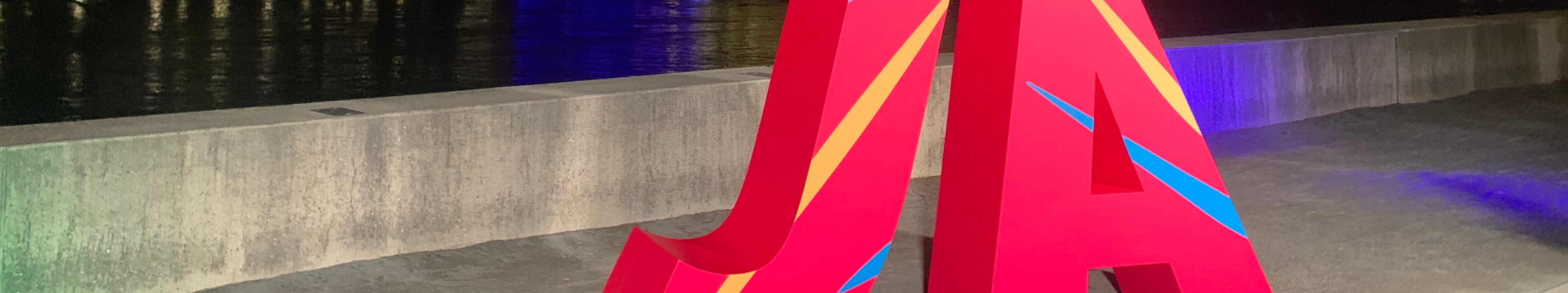 Vor der in den Farben der olympischen Ringe beleuchteten Hohenzollernbrücke und dem Dom in Köln steht ein großes rotes "Ja".