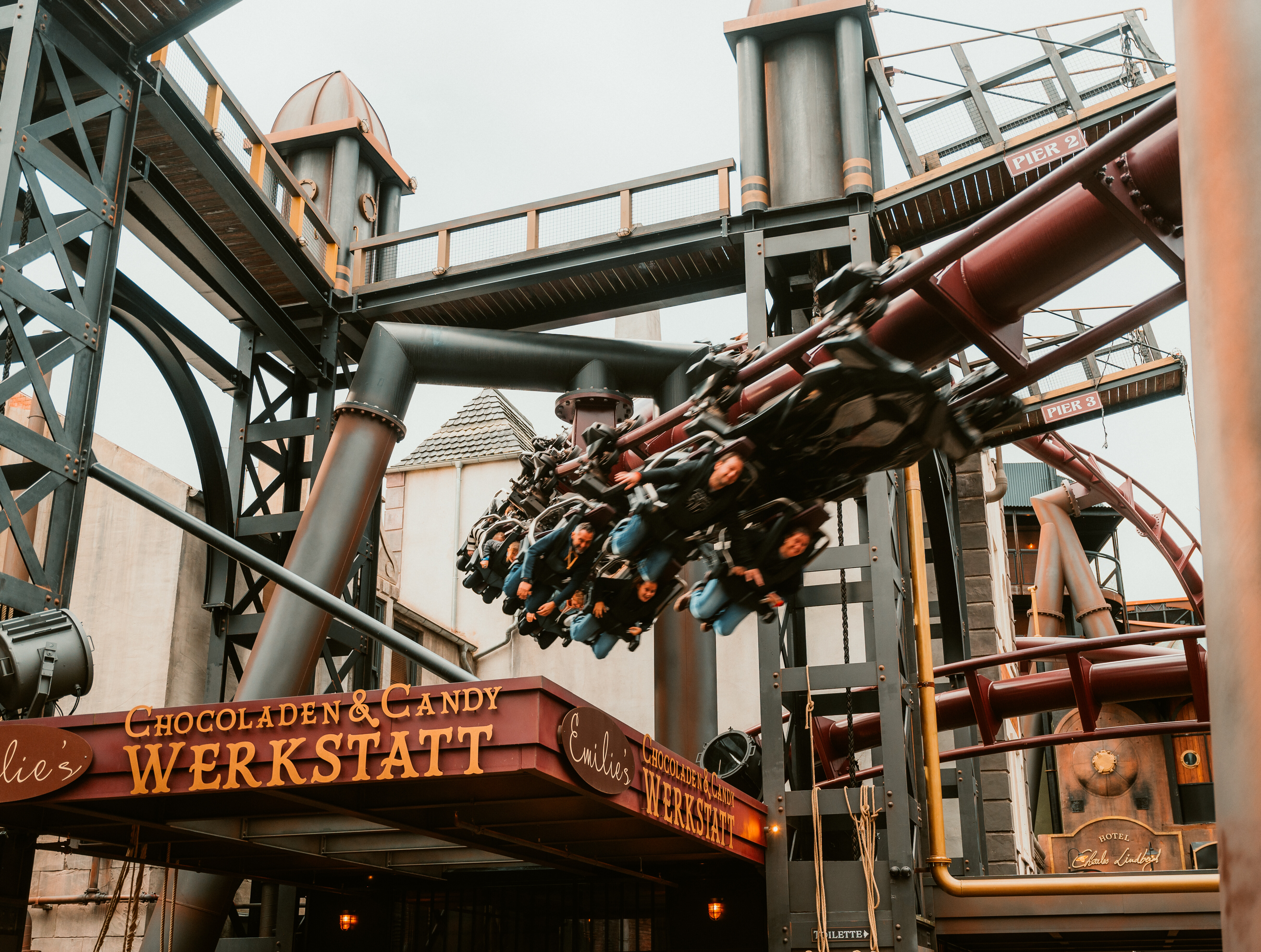 Eine Achterbahn fährt im Phantasialand Brühl durch die Themenwelt Rookburgh Candywerkstatt.