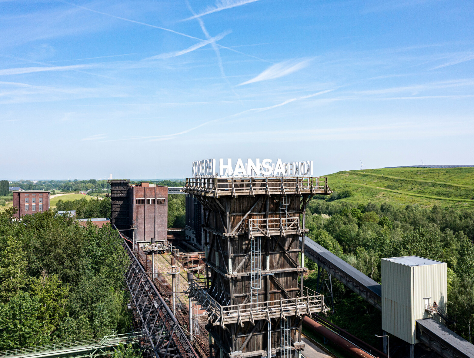 Kokerei Hansa in Dortmund © Klaus-Peter Schneider Turm der Kokerei Hansa in Dortmund, umgeben von Bäumen und dem grünen Deusenberg, einem rekultivierten Deponiegelände