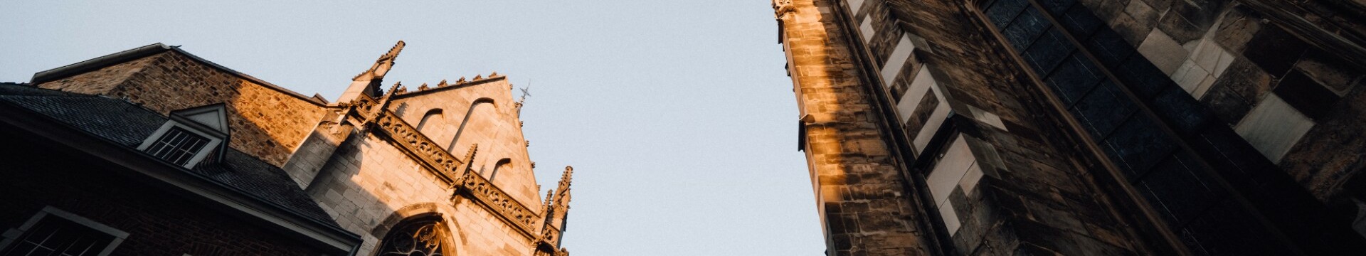 Der Aachener Dom ragt, von unten fotografiert, in den Himmel.
