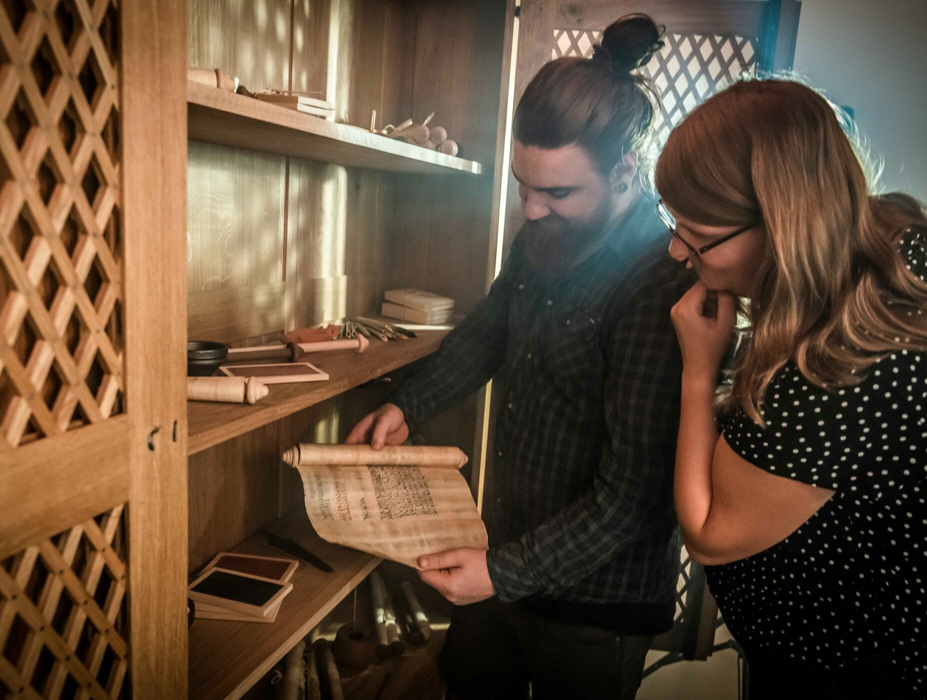 Zwei Menschen sehen sich im Escape-Room im LWL-Römermuseum in Haltern eine Papierrolle an.