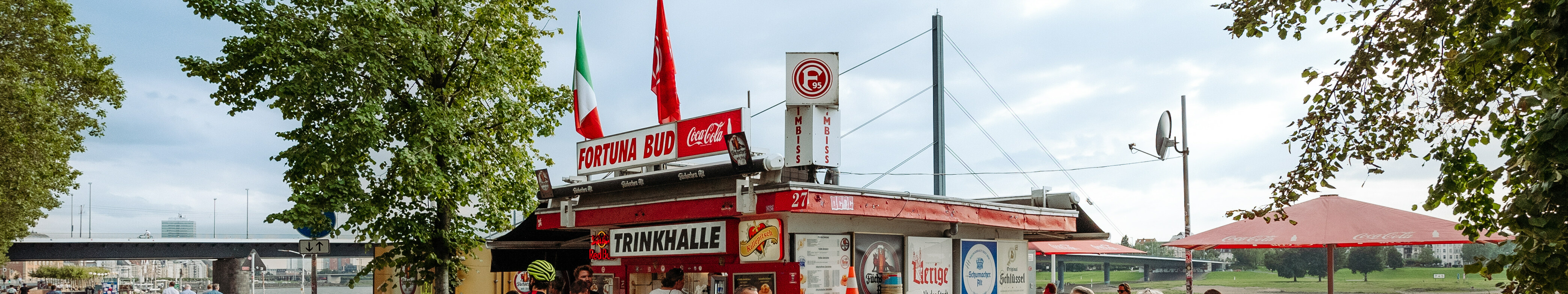 Radfahrer und Fußgänger stehen am Fortuna-Büdchen am Rhein in Düsseldorf. 