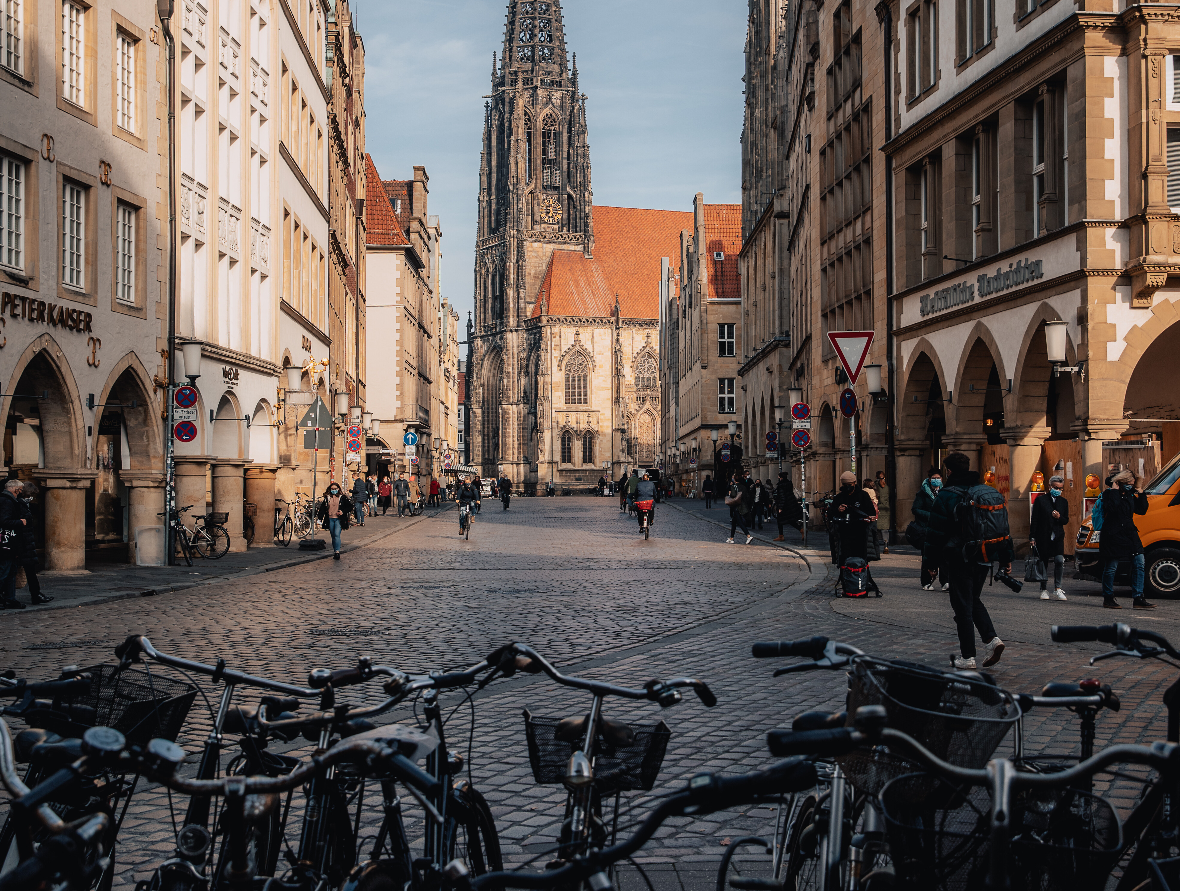 Prinzipalmarkt mit vielen Radfahrenden und Lamberti-Kirche in Münster © Lennart Pagel Blick auf den Prinzipalmarkt und die Lamberti-Kirche in Münster. Durch die Straße fahren viele Menschen auf Fahrrädern.