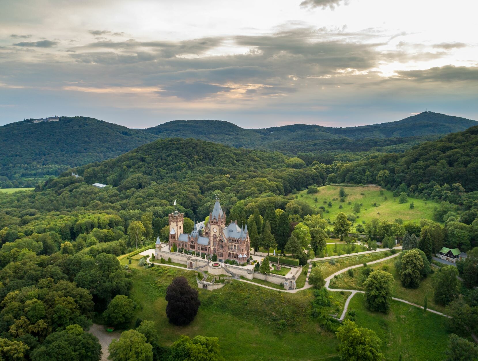 Blick auf Schloss Drachenburg, umgeben von bewaldeten Hügeln, im Naturpark Siebengebirge © Tourismus NRW e.V.