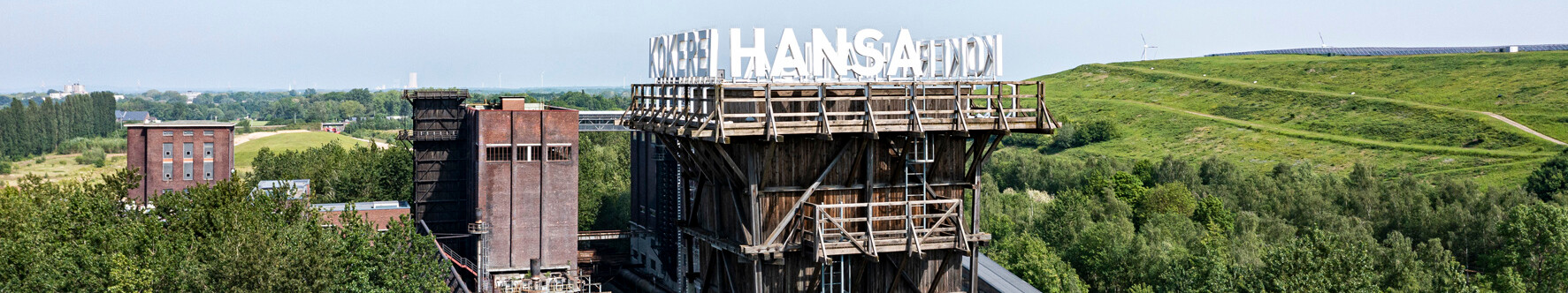 Kokerei Hansa in Dortmund © Klaus-Peter Schneider Turm der Kokerei Hansa in Dortmund, umgeben von Bäumen und dem grünen Deusenberg, einem rekultivierten Deponiegelände