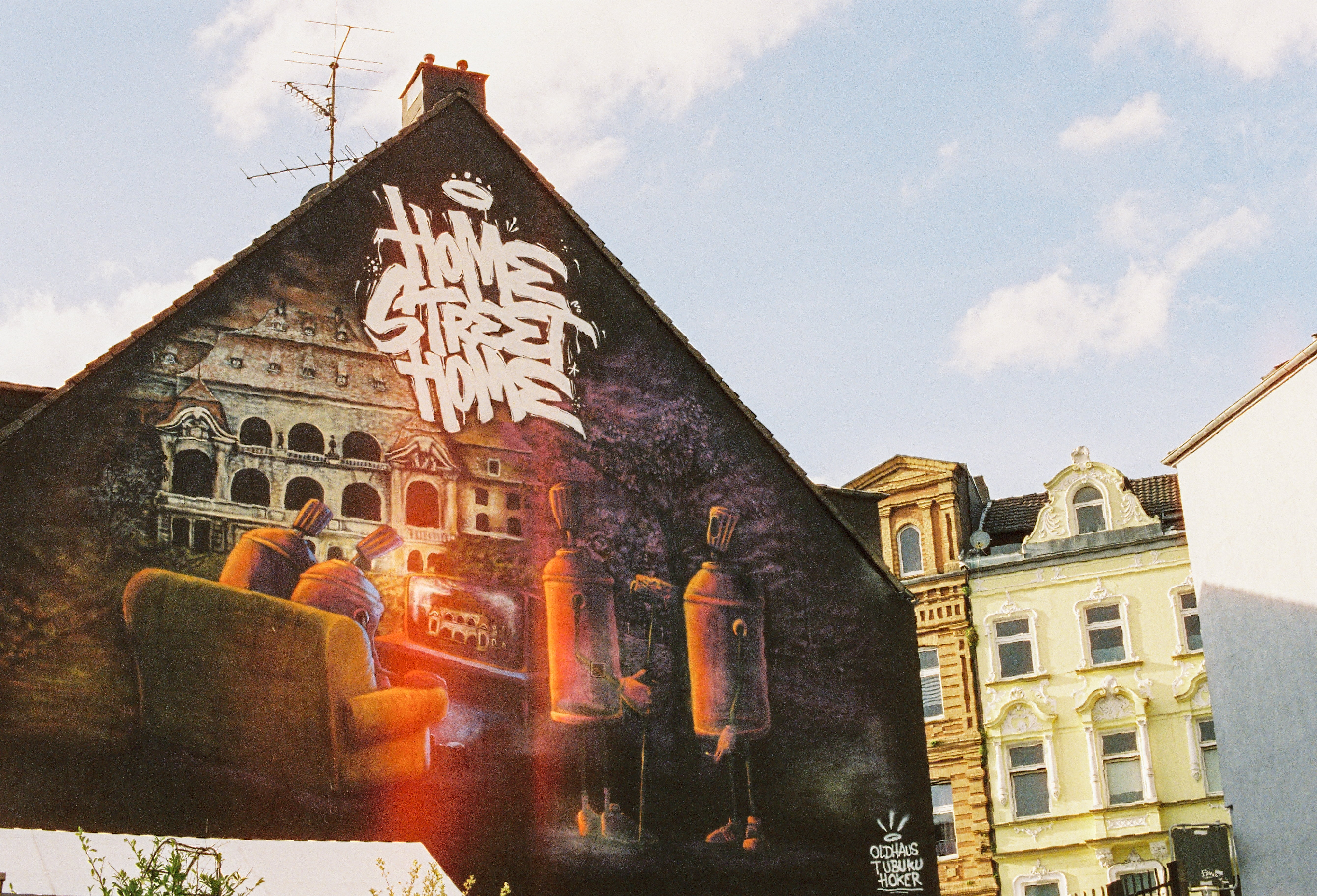 Mural "Home Street Home", ein Gemeinschaftsmotiv  von Hoker, Oldhaus & Tubuku, an einer Hausfassade in Mönchengladbach. In dem Mural werden Menschen als Spraydosen dargestellt.  © Tourismus NRW e.V./Johannes Höhn