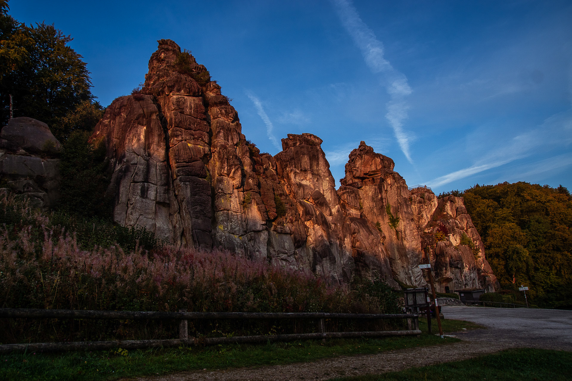 Die Felsformation Externsteine bei Horn-Bad Meinberg im Abendlicht bei blauem Himmel. 