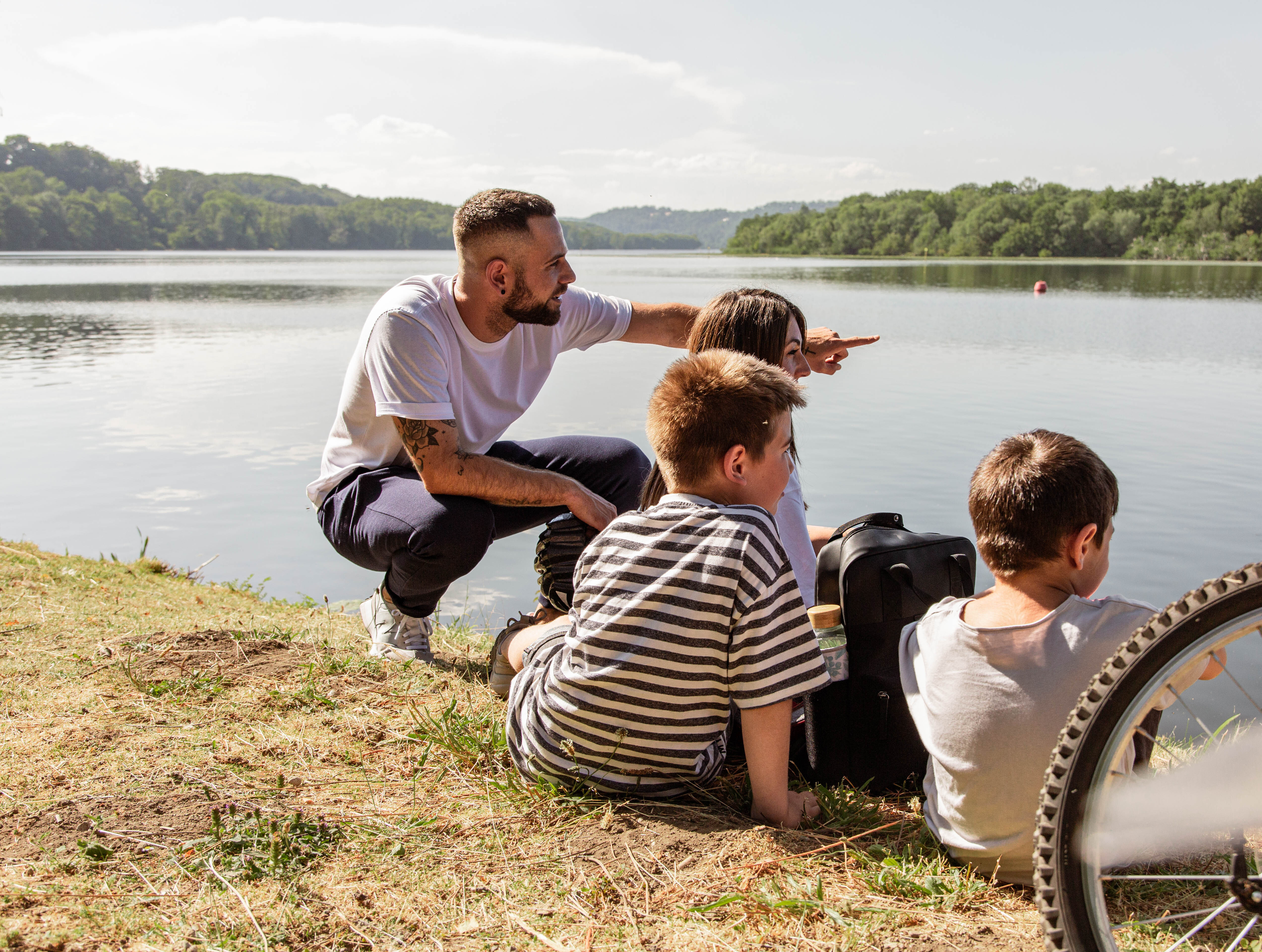 Eine Familie macht bei einer Radtour Pause an der Ruhr. 
