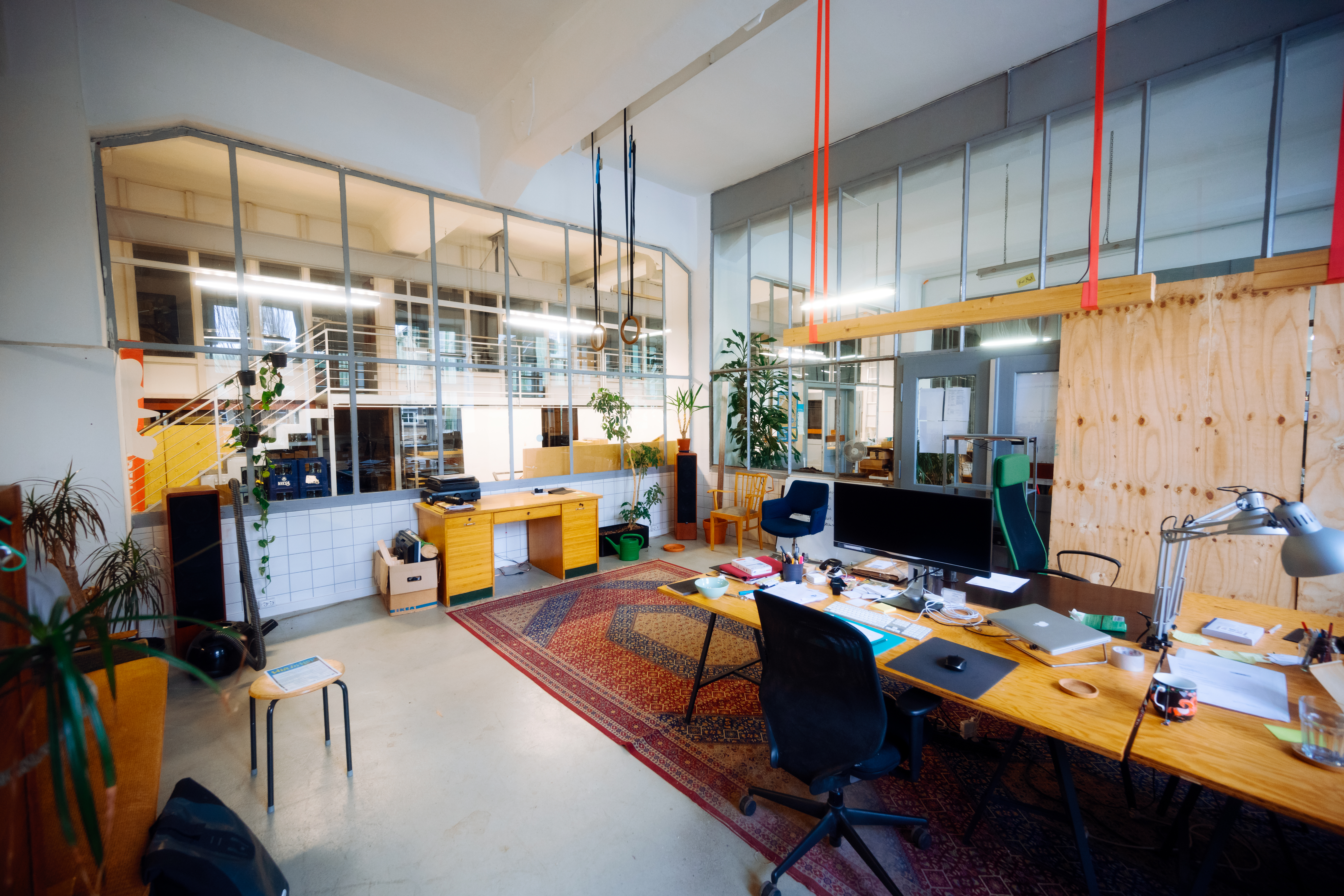 Volle Schreibtische mit Stühlen auf einem Teppich im Co-Working-Space im Union Gewerbehof in Dortmund 