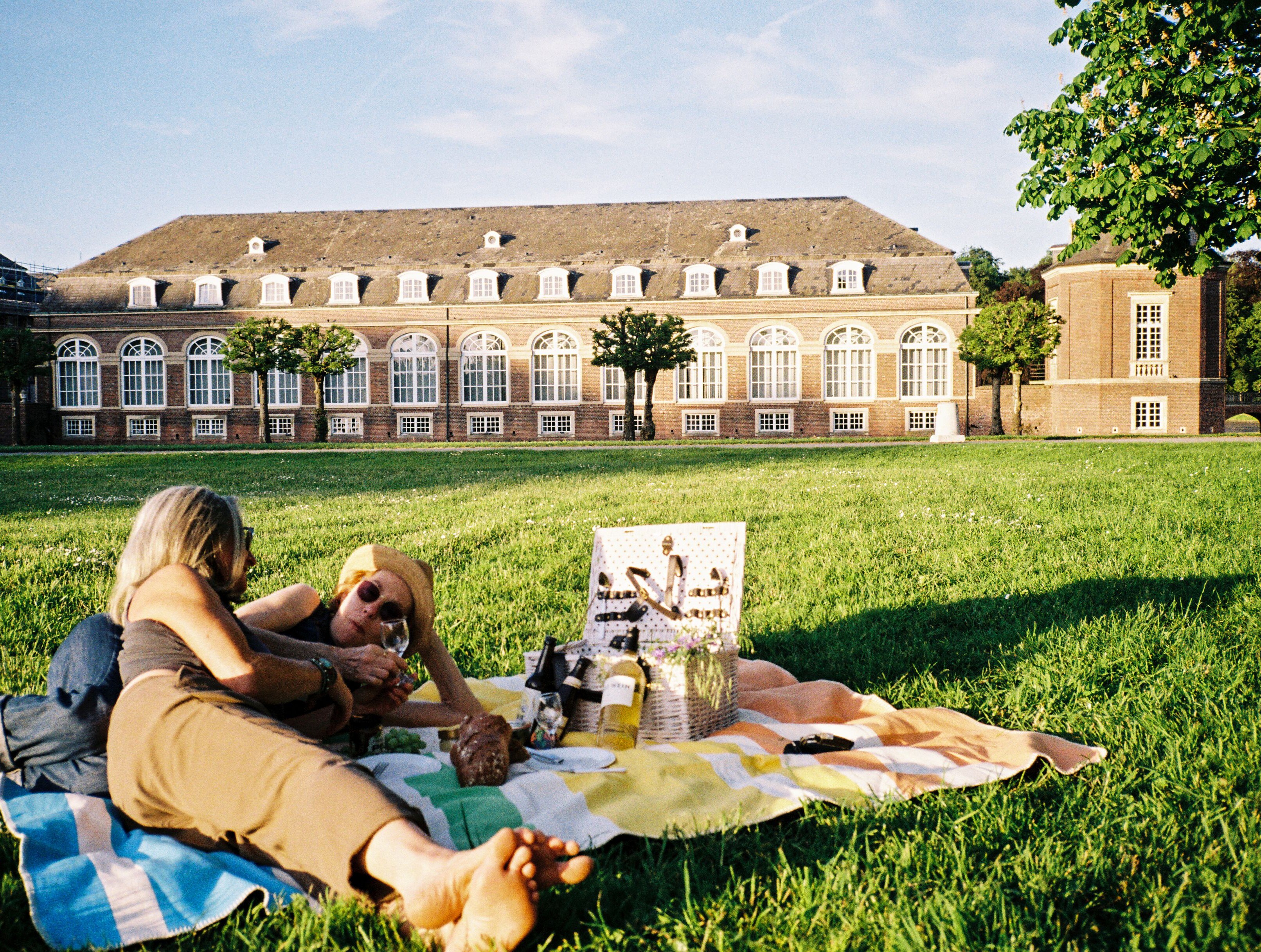 Picknick am Schloss Nordkirchen © Molle & Korn/Henri Schade Zwei Frauen liegen auf einer Picknickdecke am Schloss Nordkirchen im Münsterland.