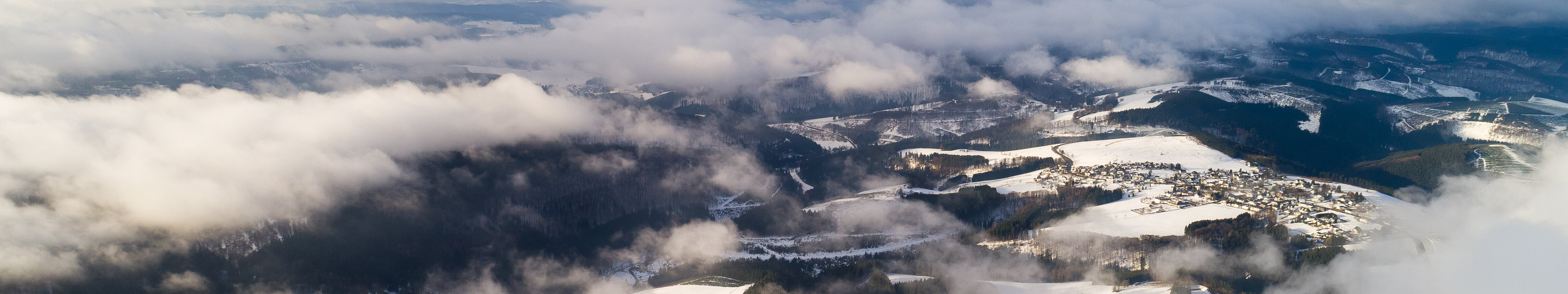 Wolken ziehen über die schneebedeckten Berge am Kahlen Asten bei Winterberg im Sauerland. © Tourismus NRW e.V.
