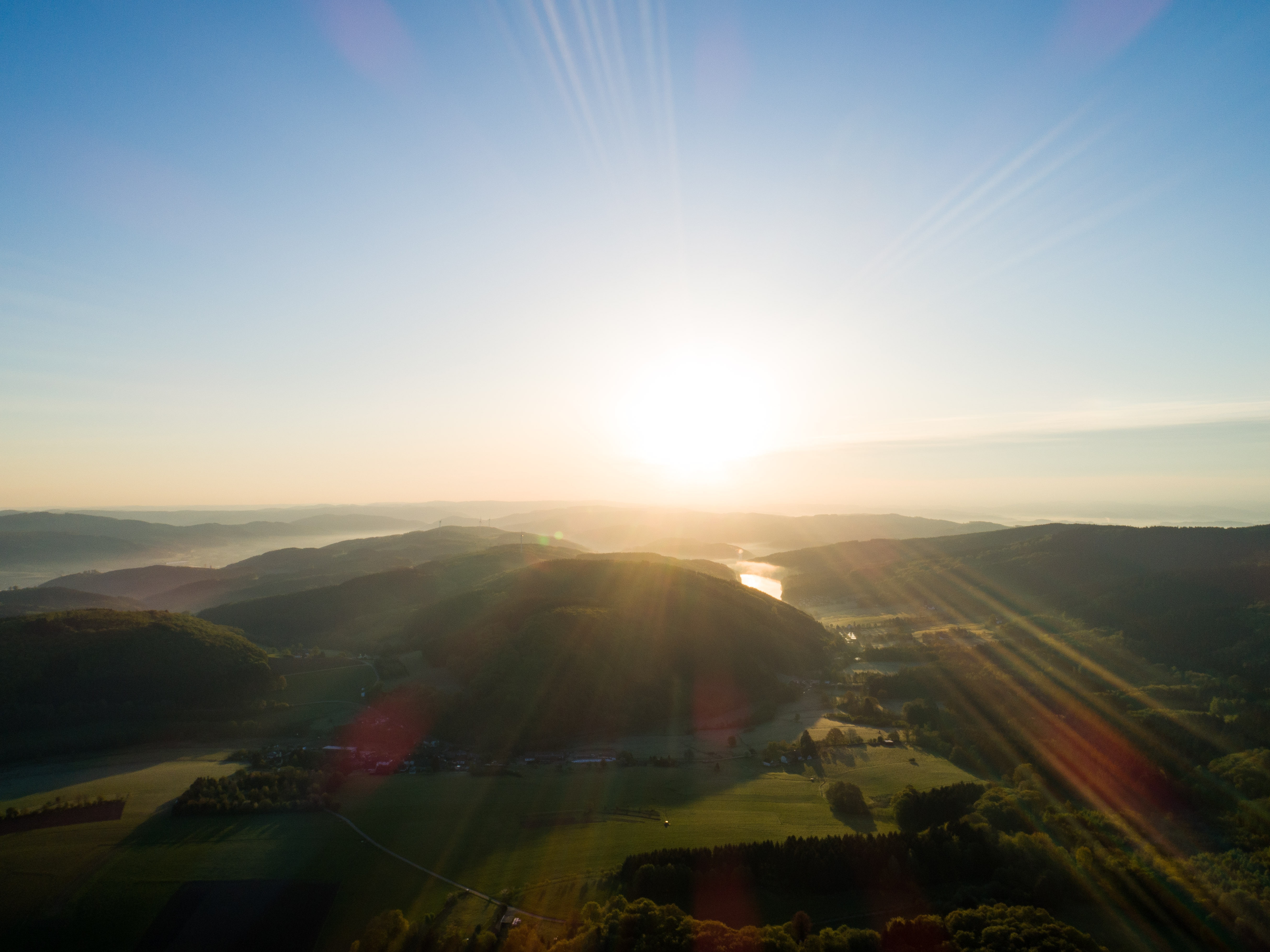 Sonnenstrahlen über der hügeligen Landschaft im Ebbegebirge bei Meinzerhagen im Sauerland 