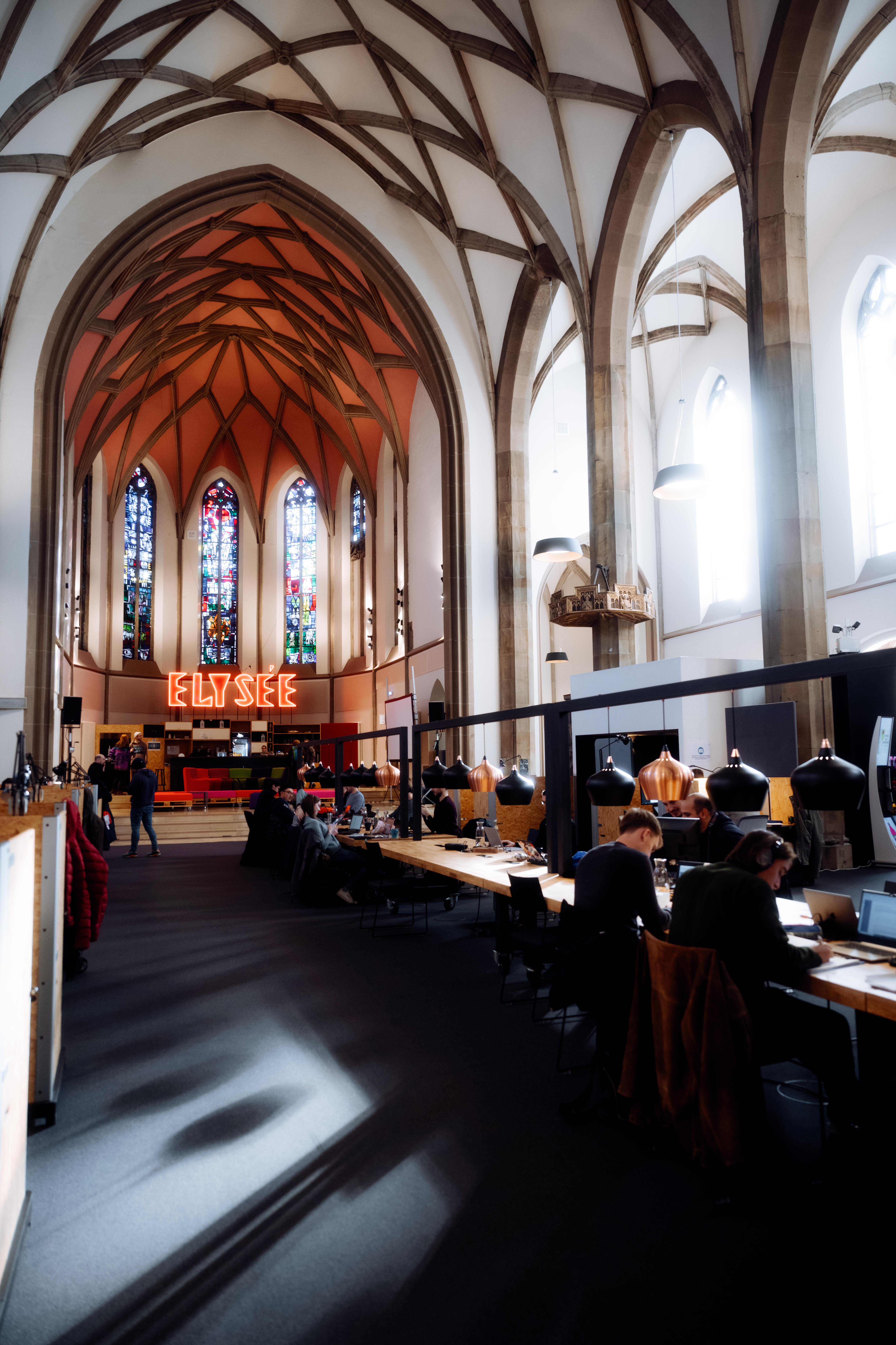 Mehrere Menschen sitzen an Schreibtischen in der Digital Church in Aachen, Deutschlands erstem Co-Working-Space in einer Kirche. 