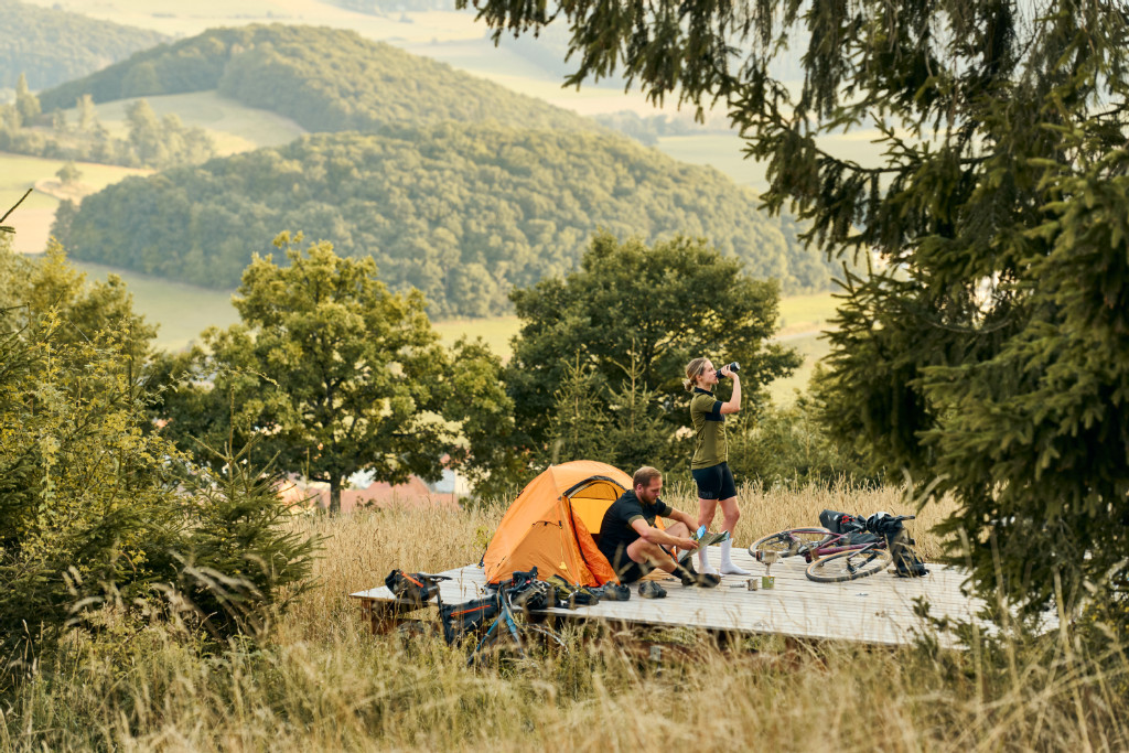 Ein Rafahrer mit seinem Zelt auf einer Trekkingplattform im Naturpark Diemelsee