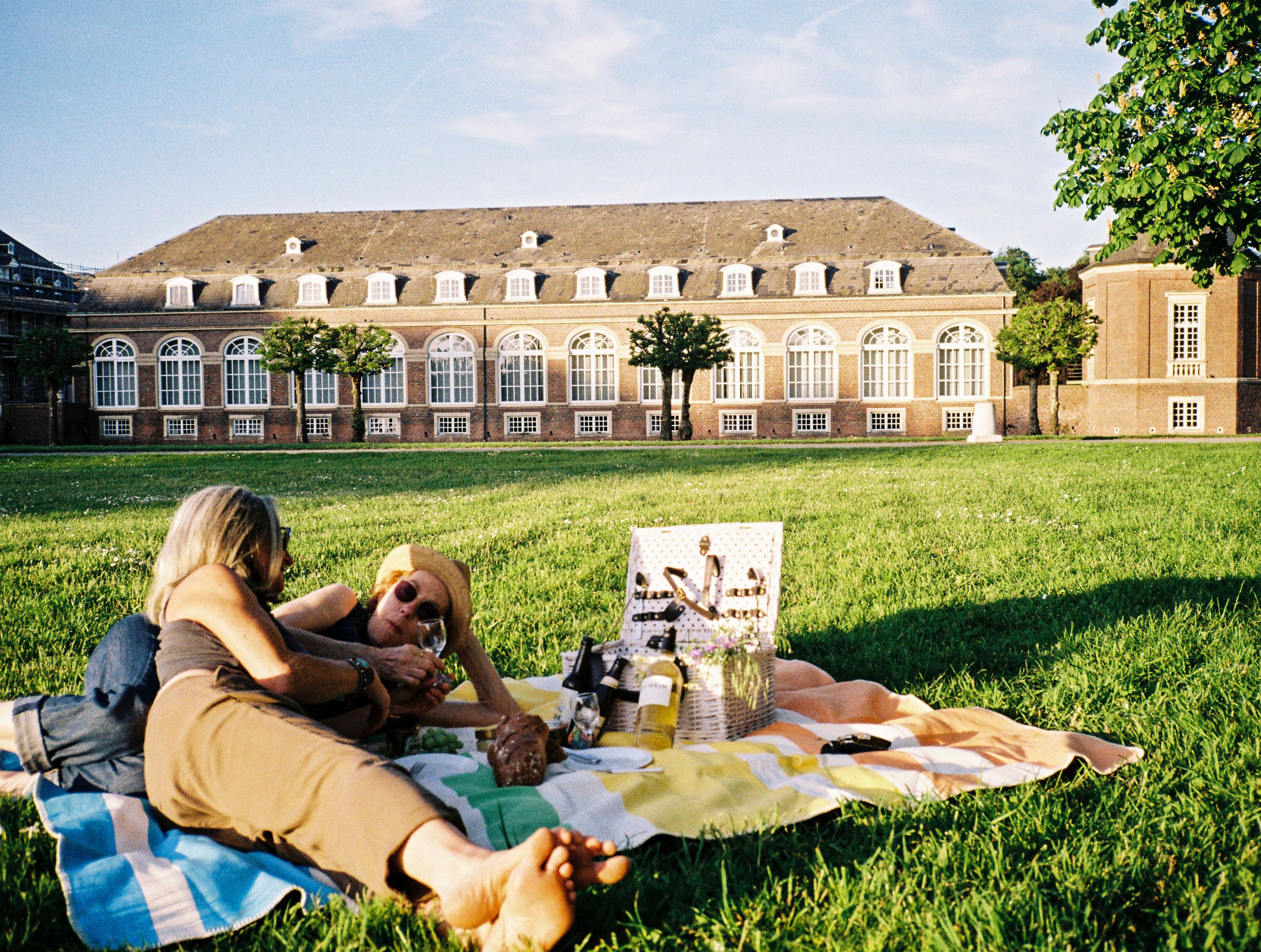 Picknick am Schloss Nordkirchen © Molle & Korn/Henri Schade Zwei Frauen liegen auf einer Picknickdecke am Schloss Nordkirchen im Münsterland.
