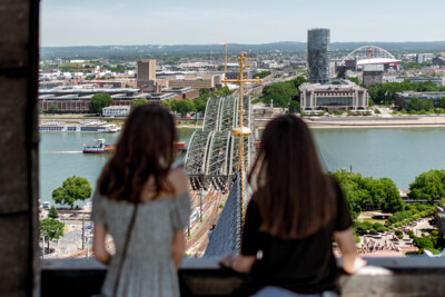 Blick auf die Hohenzollernbrücke in Köln © Tourismus NRW e.V. Zwei Menschen schauen von oben auf die Hohenzollernbrücke in Köln